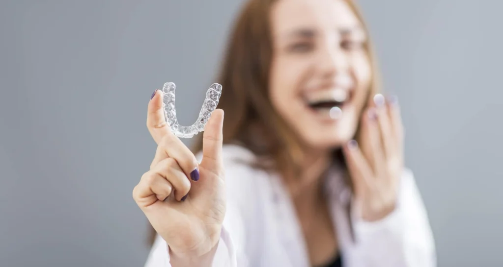 Woman showing off her clear aligner